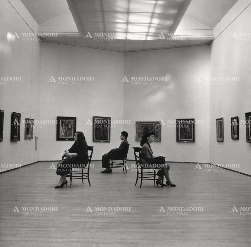 Three visitors of the Modern Art Gallery of Milan are looking at the works of the exhibition of paintings of the French painter Georges Rouault. Milan, spring 1954. SPECIAL FEE  - CONTACT US FOR NOT EDITORIAL USAGE