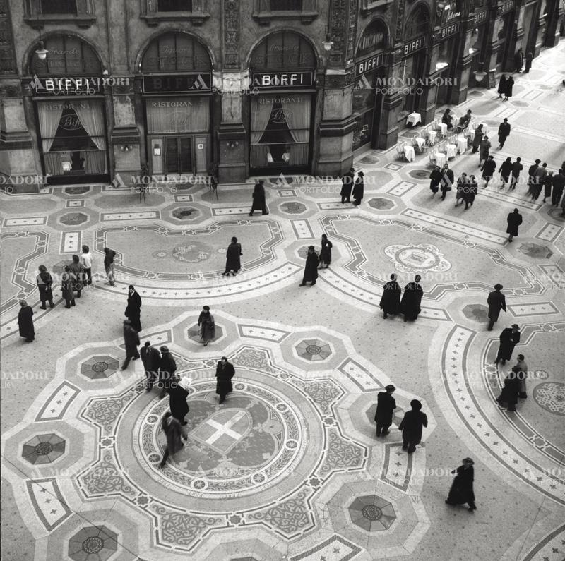 Top view of Galleria Vittorio Emanuele II, with passers-by and the historic Biffi restaurant. Milan (Italy), 1950 SPECIAL FEE - CONTACT US FOR EVERY USAGE
