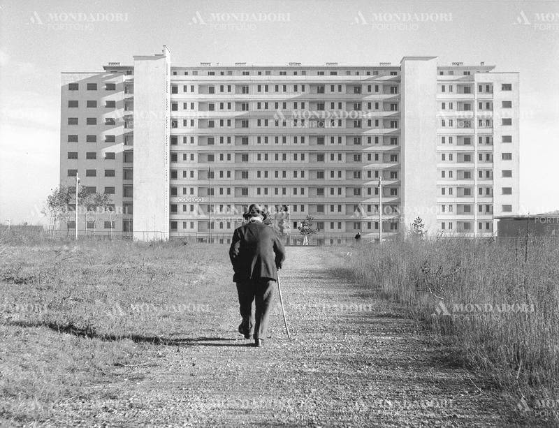 A man walking towards a building in QT8 quarter in Milan. Milan, 1960s SPECIAL FEE  - CONTACT US FOR NOT EDITORIAL USAGE