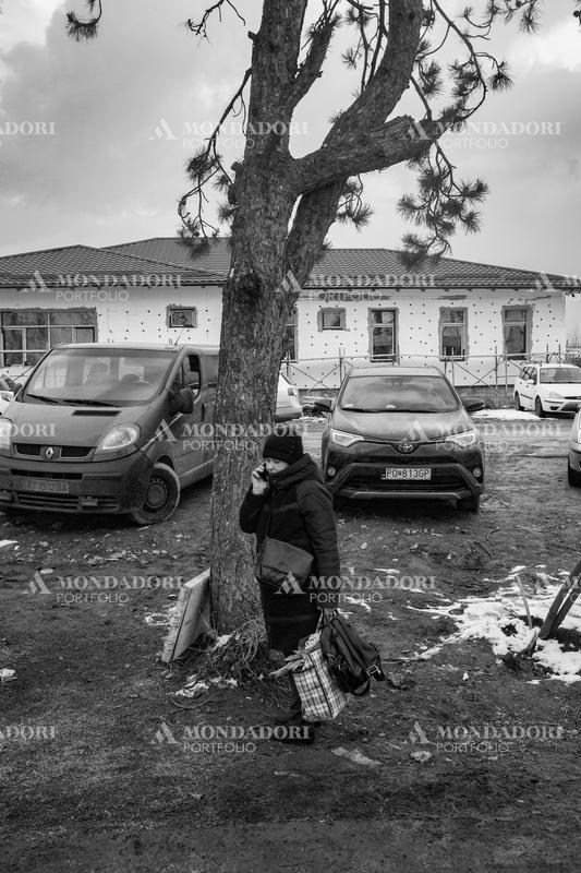 A Ukrainian woman talks on the phone with suitcases in her hand. Siret (Romania), March 8th, 2022