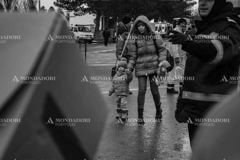 A mother with her daughter walk towards the Siret refugee reception center. Siret (Romania), March 8th, 2022