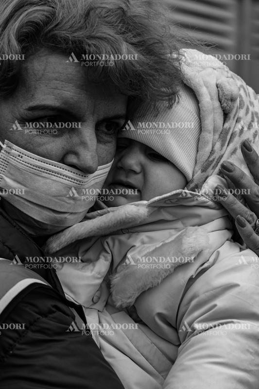 A volunteer holds a Ukrainian child in her arms. Siret (Romania), March 8th, 2022