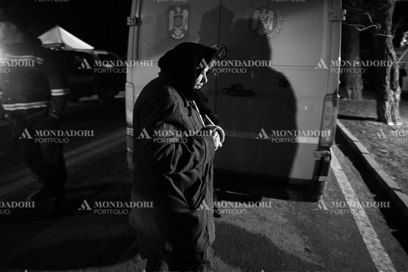 An elderly woman walks to the bus that will take her to a new destination. Siret (Romania), March 7th, 2022